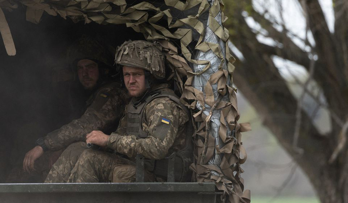 Ukrainian soldiers ride in a military vehicle